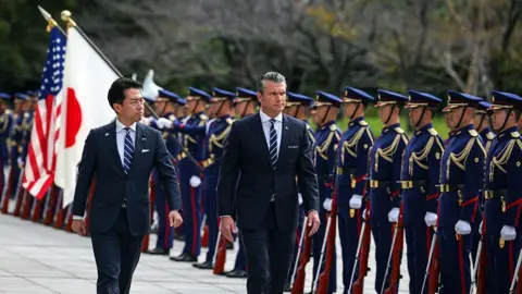 Getty Images Shinjiro Koizumi, Japan's defence minister, left, and Pete Hegseth, US secretary of defence, inspect an honor guard in Tokyo, Japan, on Wednesday, Oct. 29, 2025.