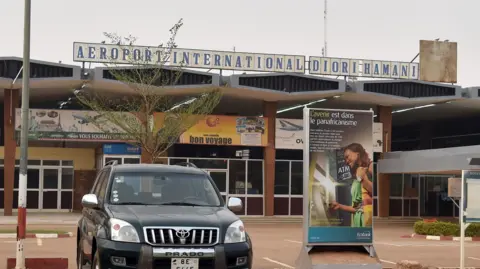 AFP via Getty Images A picture taken on February 24, 2016 shows the entrance of Diori Hamani International airport of Niamey, with a black car in the foregrouns
