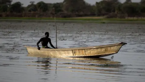AFP via Getty Images A lone fisherman steers his boat on Lake Chad