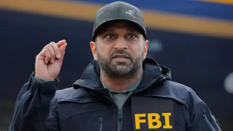Reuters Kash Patelgestures while wearing a baseball cap and an FBI branded jackte