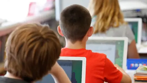Getty Images Close up image of students using laptops in a classroom.