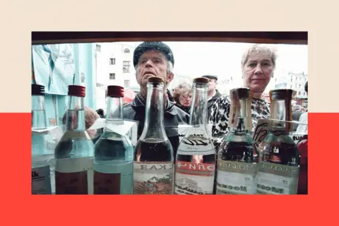 AFP via Getty Images A man and a woman look into a kiosk selling various brands of vodka in clear bottles.