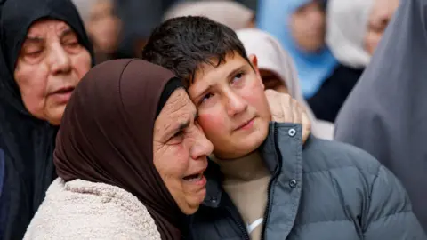 Reuters Khaled Bani Odeh is embraced by a woman during the funeral for his parents and two of his brothers in Tammun, in the Israeli-occupied West Bank (15 March 2026)