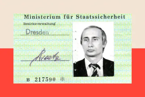 Stasi Records Agency Dresden (Public Domain) A pale green Stasi identity card bears Vladimir Putin's photograph in black and white on the right. He is wearing a dark suit and stripey tie, his hair is fair and he is looking off-camera into the distance.