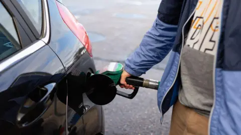 Getty Images A man filling up his car at a filling station