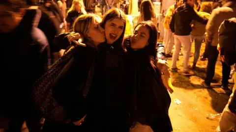 NurPhoto via Getty Images Revellers are seen in the streets in Budapest, Hungary on 13 April, 2026
