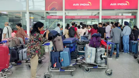 Reuters Queues at Delhi airport amid cancellations and delays.