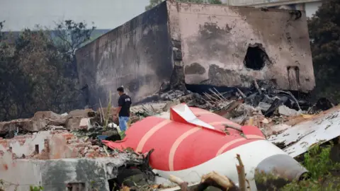 Reuters A firefighter stands next to the crashed Air India Boeing 787-8 Dreamliner aircraft, in Ahmedabad, India, June 13, 2025.