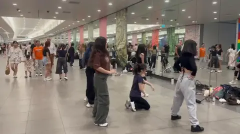 The Fun of Travel (thefunoftravel.com) Young Singaporeans practising dance routines in front of the mirrors at Bayfront MRT station