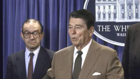 The Chronicle Collection via Getty Images Ronald Reagan and Alan Greenspan in 1987. They are standing at the podium in the White House. President Reagan is speaking and Alan Greenspan is waiting to be introduced.