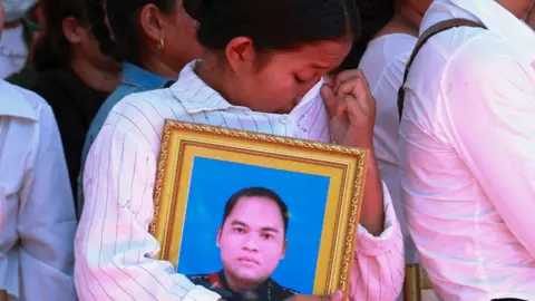 Reuters A woman weeps as she holds a photograph of one of the soldiers killed in an ammunition explosion at a C