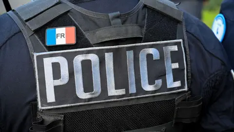 Getty Images The bulletproof vest of an unidentified police officer is seen from behind in an archive image. The vest says 'Police' and has a badge bearing the French flag on.