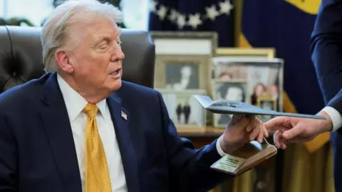 Reuters US President Donald Trump receives a model of a B‑2 bomber commemorating