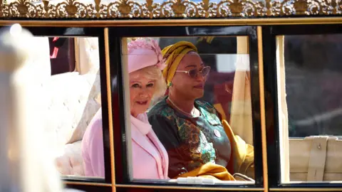 PA Media Queen Camilla and Nigeria's First Lady Oluremi Tinubu look on from a carriage 