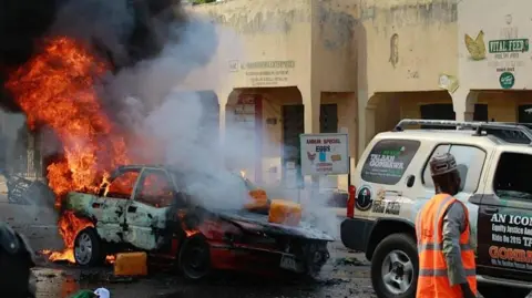 Anadolu via Getty Images A car on fire after bombing in Nigeria's north eastern Gombe state in 2015