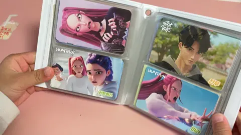 Supplied A child's hands holding up an album with cards of characters of Kpop Demon Hunters