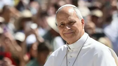 AFP via Getty Images Pope Leo, in his white papal robe and skullcap
