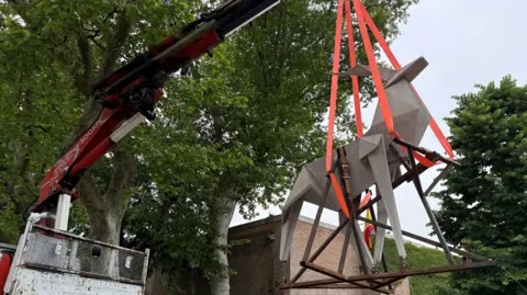 Zhanna Kadyrova A sculpture of an origami deer cast in concrete hangs suspended from a crane. It is the work of Ukrainian artist Zhanna Kadyrova. 