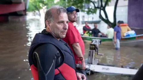 Fernando Otto/BBC Brasil Ivan Brizola speaks to BBC Brasil as he takes a break from rescuing stranded people 