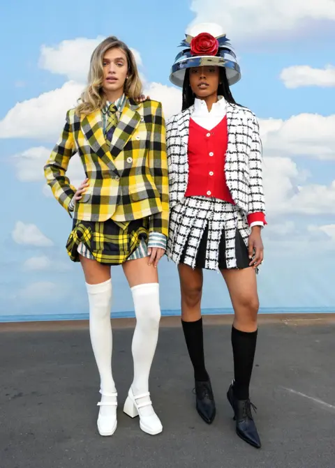 Getty Images Two models searing chequered jackets and mini shirks inspired by the 1995 film Clueless