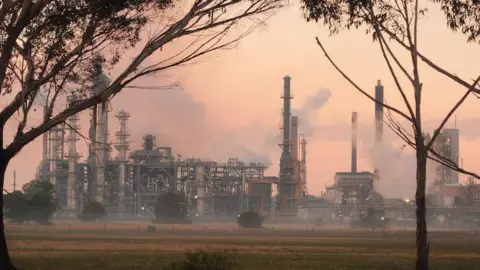 Australian Broadcasting Corporation/Tara Whitchurch An oil refinery with smoke seen billowing out from several areas