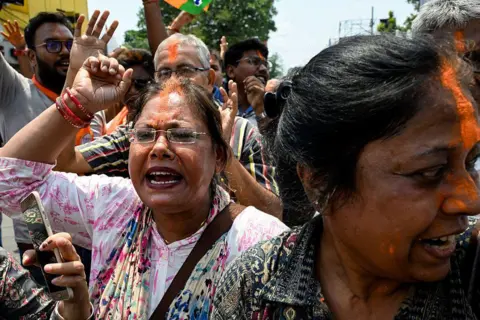 AFP via Getty Images Bharatiya Janata Party (BJP) supporters celebrate along a street near her residence of West Bengal chief minister and All India Trinamool Congress (TMC) party chairperson Mamata Banerjee, in Kolkata on May 4, 2026. 