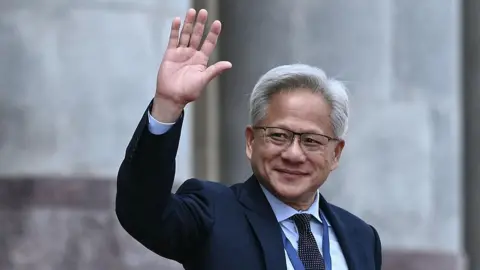 Getty Images Nvidia founder and CEO Jensen Huang waves after a welcome ceremony for US President Donald Trump at the Great Hall of the People in Beijing on May 14, 2026.