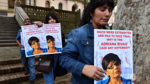 Alamy Members of the Chilean Australian community from the National Campaign for Truth and Justice in Chile carry pictures of Adriana Rivas at Central Local Court in Sydney, Tuesday, April 2, 2019. (AAP Image/Dean Lewins)