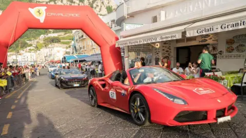 Getty Images A convoy of Ferrari supercars turn up for an event along the Amalfi Coast