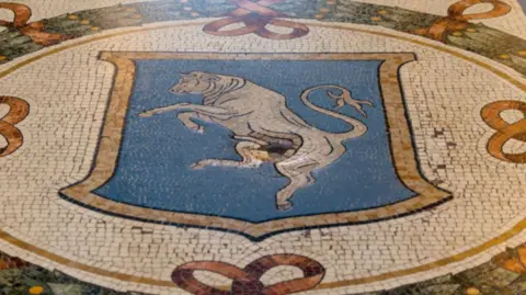 Getty Images A small crater in the centre of the bull mosaic in the Galleria Vittorio Emanuele II in Milan, Italy.
