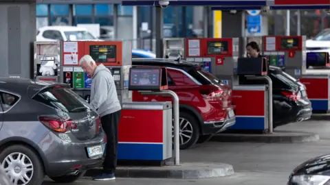 Reuters People at a petrol station in Slovenia