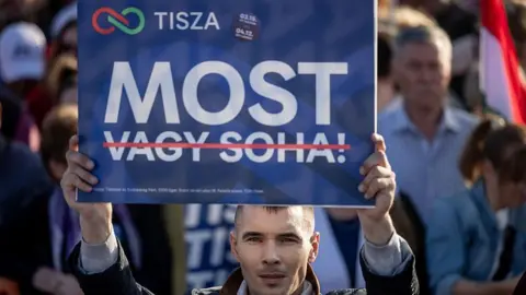 Getty Images A Magyar supporter holds up a placard that reads "Now" - with the words "or never" crossed out