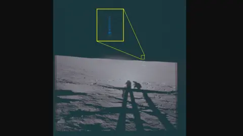 US Department of Defense A photo from the surface of the Moon. It shows the shadows of two astronauts, and in the distance what looks like a flash of blue light. It is highlighted and englarged