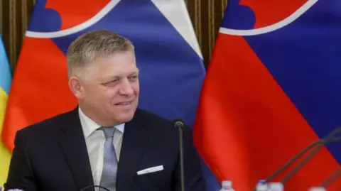 Getty Robert Fico smiling with Slovak flags in background