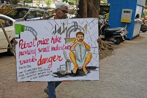 LightRocket via Getty Images A teacher from Gurukul school of art carries back a poster on worries faced by common man due to the ongoing war between US-Iran. Indian Prime Minister Narendra Modi made seven appeals to citizens while addressing a gathering in Hyderabad, urging measures to reduce fuel and oil consumption amid concerns over global conflicts affecting supplies. He encouraged people to avoid buying gold for a year, work from home when possible, use public transport and carpooling, shift to electric vehicles, reduce cooking oil use, support organic farming, and buy fewer foreign-brand products. Modi said these steps could help reduce pressure on India's foreign exchange reserves and energy demand. (Photo by Ashish Vaishnav/SOPA Images/LightRocket via Getty Images)