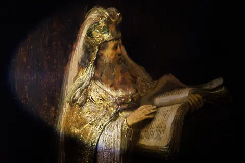 Kelly Schenk, Rijksmuseum Detail showing the high priest Zacharias holding a large book and wearing ornate robes in Rembrandt’s Vision of Zacharias in the Temple (1633)