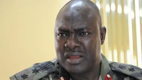 AFP via Getty Images A head and shoulders image of Rabe Abubakar wearing a military uniform.