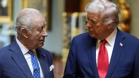 Reuters King Charles and US President Donald Trump at Windsor Castle, September 2025 in Windsor Castle. Both are wearing dark suits.
