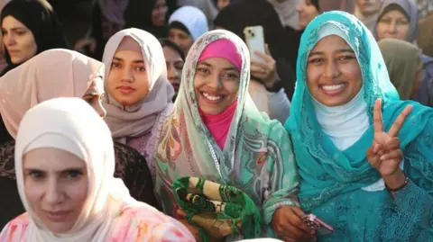 Reuters A group of women pose for the camera while attending prayers to mark the end of Ramadan
