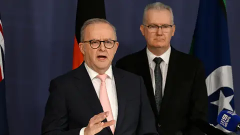 Getty Images Anthony Albanese speaks at a press conference, Home Affairs Minister Tony Burke behind him