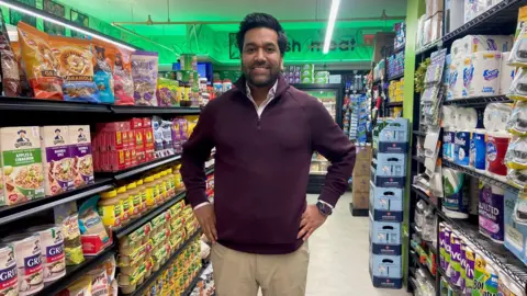 Danielle Kaye Alap Vora stands in the aisle of his grocery store in New York