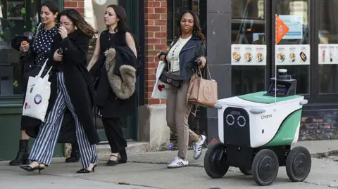 AFP via Getty Images A delivery robot on a sidewalk in Chicago