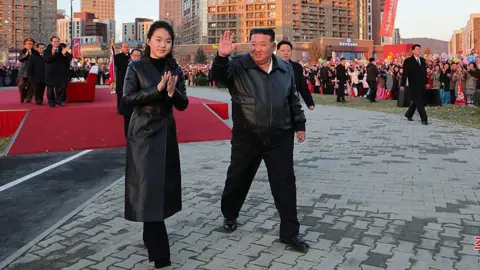 Getty via KCNA North Korean leader Kim Jong Un (C) and his daughter Ju Ae (L) responding to citizens