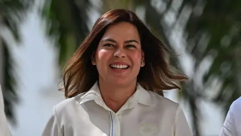 Getty Images Sara Duterte walking and smiling with the wind blowing her hair