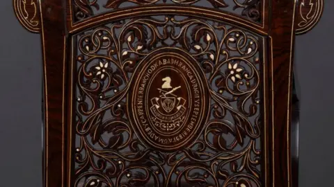 Vivek Gandhi ... a plaque on the back is inscribed with the name of the carpenter who made the chair and the month and year it was made in.