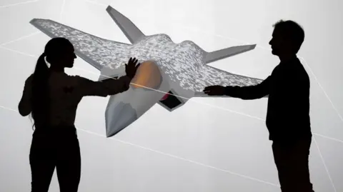 Dassault Aviation A man and woman touch a mock-up of a plane