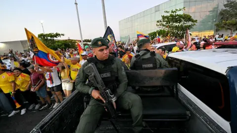 AFP via Getty Images GOES (Special Operations Group) police officers patrol in a pickup while supporters of Colombia's presidential candidate Abelardo de la Espriella, of the Salvadores de la Patria movement, celebrate during the first exit poll results of the presidential election in Barranquilla, Colombia, on May 31, 2026.