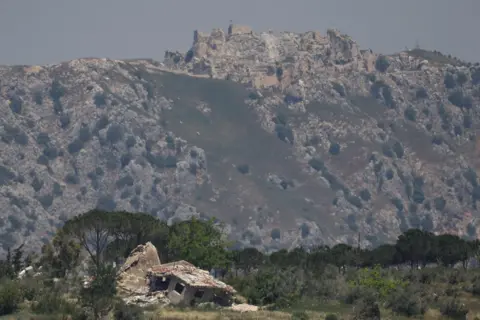 Reuters A destroyed house in southern Lebanon, with Beaufort Castle in the background, as seen from northern Israel (2 June 2026)