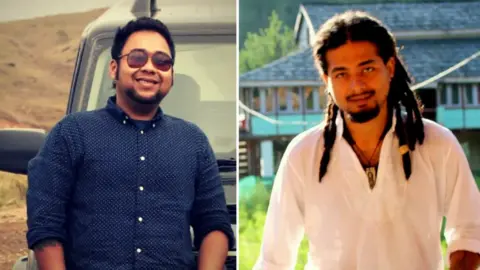 BBC Abhijeet Nath (left), wearing a blue shirt and sporting sunglasses, smiles for a photo, standing in front of a black SUV; Nilotpal Das, wearing a white kurta, a pendant tied to a thread around his neck and sporting dreadlocks, poses for the camera, behind him one can see a turquoise-coloured building. 
