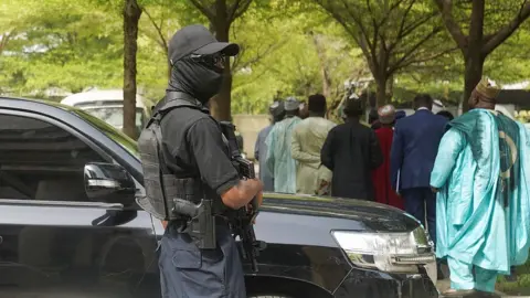 Reuters An armed officer in black with shades, cap and facemask stands guard outside the Federal High Court in Abuja on Wednesday 22 April 2026.